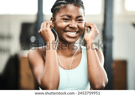 Earphones, healthy and black girl in gym, music and listening for exercise, online and streaming on app. Fitness, audio and practice with technology, internet and radio for wellness and training