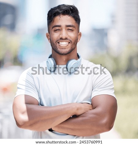Man, arms crossed in portrait and headphone outdoor for fitness, music or audio streaming with personal trainer in city. Confident, proud and athlete with wireless tech for radio, podcast or playlist