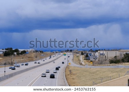 Highway road with driving cars traffic against dramatic sky with storm clouds. Urban landscape photo.