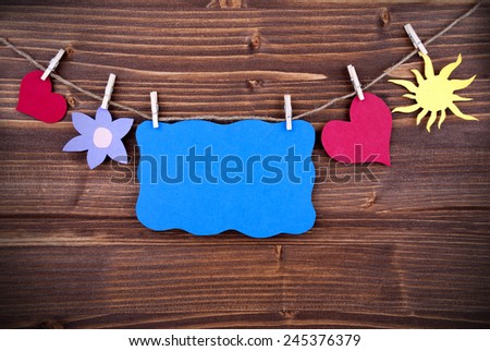 Blue Tag Or Label With Hearts And Flower And Sun On A Line With Copy Space For Your Free Text Here On Wooden Background, Four Symbols, Vintage, Retro And Old Fashion Style With Frame