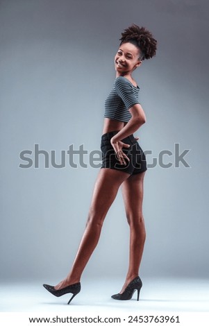Fashion-forward young lady elegantly poised in sparkling heels Royalty-Free Stock Photo #2453763961