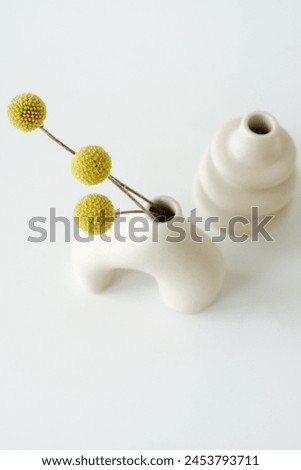 Modern beige ceramic vases with dry  grass on white table near white wall. Copy space. Minimal Scandinavian interior accessories. Aesthetic.