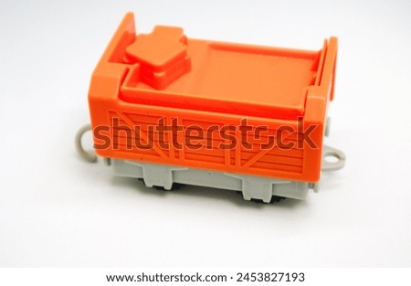 a mini orange and gray carriage toy for children isolated on white background