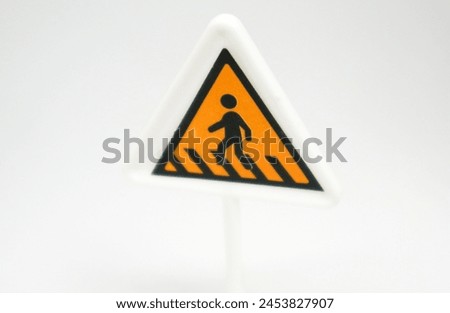 a mini triangle shaped cross road sign as toy for children isolated on white background