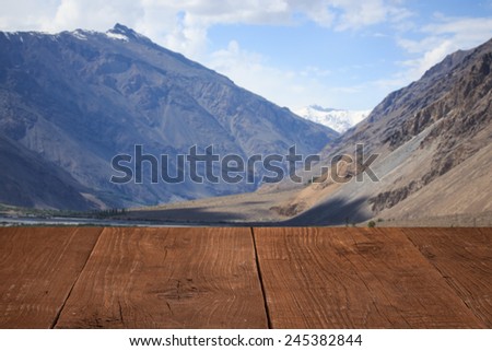 Wood flooring with a view of the clouds over the mountains.