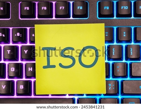 The concept of ISO quality control certification approval. Abbreviation ISO it is written on a yellow sticker on the illuminated keyboard