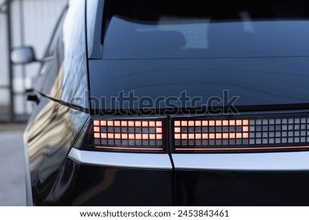 Close up detail on one of the LED red taillight modern luxury car. Car back lights shining. Exterior detail automobile. Tail light car. Detail on the rear light of a car.