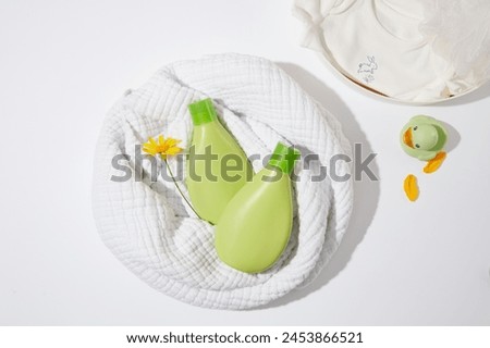 Baby bath accessories layout from top view with some blank label bottle lay on linen towel. High angle shot photography of bath products for baby care, blank space for designing