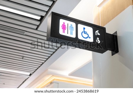 Modern public toilet sign on the wall. Public restroom signs with a disabled access symbol.
