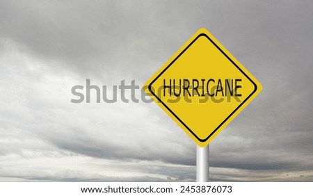 Hurricane Idalia warning sign against a powerful stormy background with copy space. Dirty and angled sign with cyclonic winds add to the drama.hurricane season sign on cloudy background Royalty-Free Stock Photo #2453876073