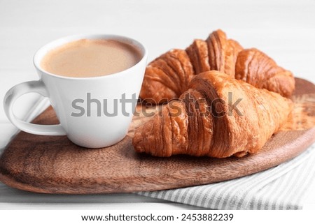 Tasty breakfast. Cup of coffee and croissants on table, closeup