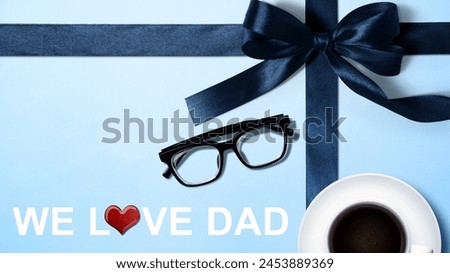 Black ribbon and eyeglasses with a red heart and We Love Dad text. Fathers day concept