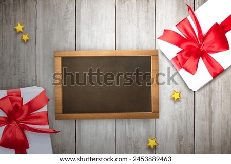 Gift box and empty small chalkboard on wooden table. Empty small chalkboard for copy space