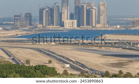 Construction of new skyscrapers in Dubai Creek Harbor aerial timelapse. Dubai - UAE. Top view from Dubai downtown with traffic on a highway