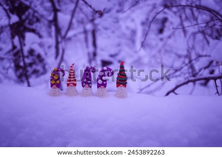 Toy dwarfs made of plasticine on a background of snow. Winter evening.