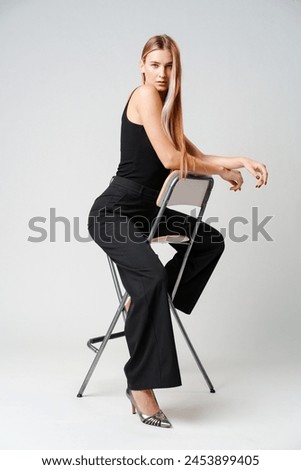 Young Woman Sitting on Chair Posing for Picture