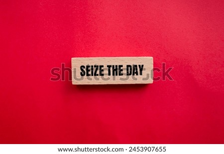 Seize the day words written on wooden block with red background. Conceptual seize the day symbol. Copy space. Royalty-Free Stock Photo #2453907655