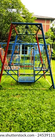 An Empty Colorful Tandem Swinging in School Park