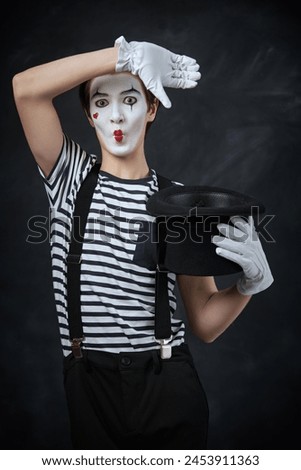 Portrait of a mime guy with sad eyes. Black chalkboard background. Retro style. Actor's emotions. Pantomime theater.