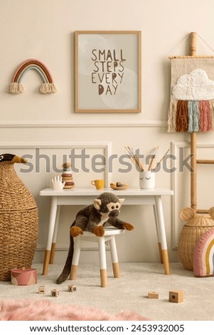 Cozy composition of kids room interior with mock up poster frame, white desk, animal wicker basket, plush monkey toys, rainbow ornament, wooden blocks and personal accessories. Home decor. Template.