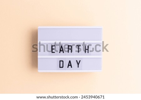 Earth day. White lightbox with letters on a beige background. 