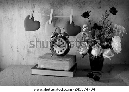 still life art photography love concept on hanging hearts vintage alarm clock roses and bouquet black and white version