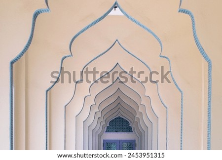 Interior diminishing perspective view of hallway along with gable partitions wall at Bang O mosque leading into entrance blue door. Mosque architecture and art concept, Space for text, Selective focus Royalty-Free Stock Photo #2453951315