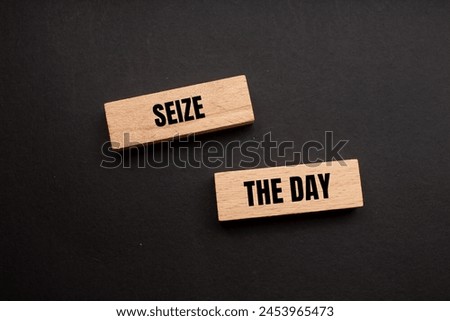 Seize the day words written on wooden blocks with black background. Conceptual seize the day symbol. Copy space. Royalty-Free Stock Photo #2453965473
