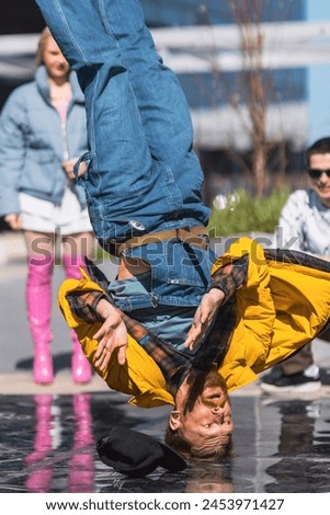 Vertical Screen: Young And Athletic B-Boy Breakdancing To Break Beats On The City Street In The Circle Of Friends. Group Of Fashionable People Supporting Professional Performer Who Is Doing Headspin. Royalty-Free Stock Photo #2453971427