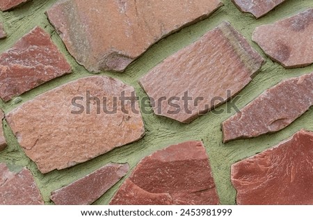 It's photo of colorful stones on green background. It is close up of multicolored stone wall of the building. Its photo of mosaic stone tile floor