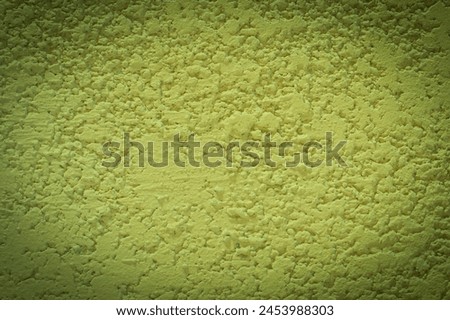 Light green paint on rough plaster wall solid background structure with dark vignette abstract design.