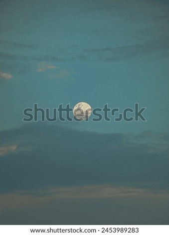 Beautiful full moon in cloudy sky in the afternoon