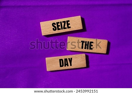 Seize the day words written on wooden blocks with purple background. Conceptual seize the day symbol. Copy space. Royalty-Free Stock Photo #2453992151
