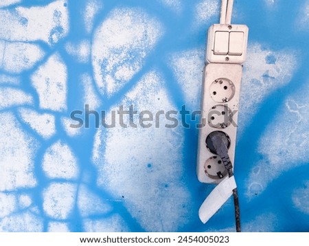 The moldy blue wall texture creates an abstract shape, and an electrical socket can be used as a background