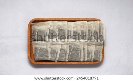 
Teabags on a wooden coaster, on a white background