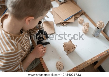 A curious boy examines a piece of cardboard through an antique microscope, his face a picture of focus and wonder, embodying the joy of discovery.