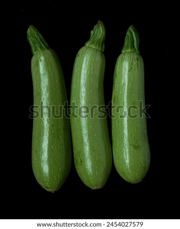 3 three fresh whole green zucchini. Clipping path. isolated on black background.