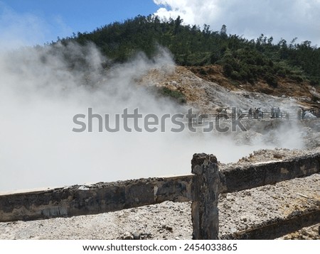 the atmosphere of the Dieng Banjarnegara crater with thick smoke and green trees