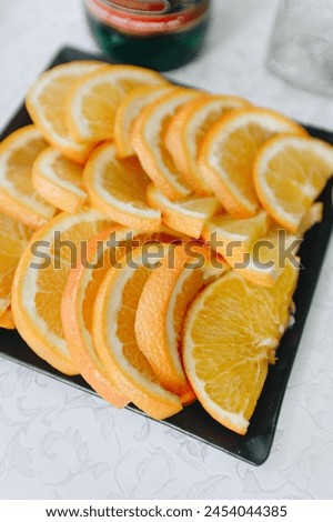 sliced ​​oranges for a snack on a holiday table on a black plate close-up