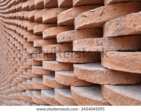 Picture of a wall made of red bricks stacked in a row.