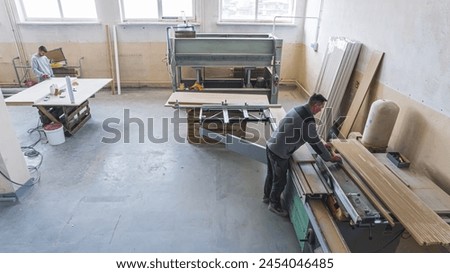 two carpenters working on wood with different tool and machines. High quality photo
