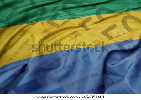 waving colorful national flag of gabon on a euro money banknotes background. finance concept. macro shot