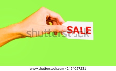 banner with the word sell, woman's hand holding paper with the word sale, green background, Jombang-Indonesia, 25 April 2024