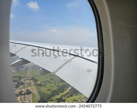 A View of the Wing of an Airplane From a Window Royalty-Free Stock Photo #2454072775