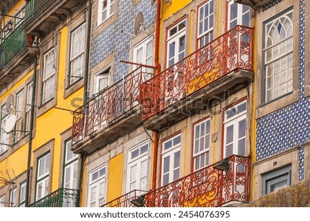 Colored walls of house with tiles in the center of Porto Portugal and steel balconies.