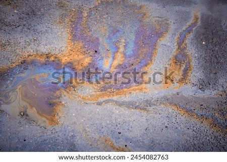 Oil rainbow gasoline spill on asphalt. Rainbow stains of oil and gasoline Royalty-Free Stock Photo #2454082763