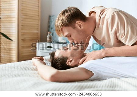 Two men sharing a tender kiss on a bed. Royalty-Free Stock Photo #2454086633