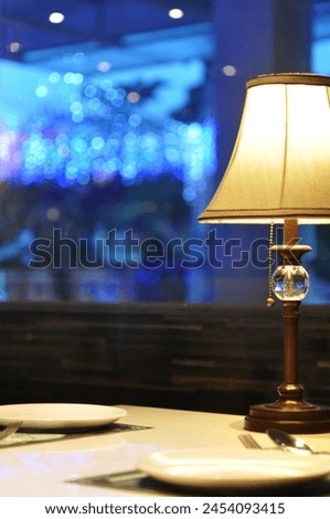 A close up picture of elegant table arrangement for dinner at a fancy restaurant with classic table lamp detail as an accent in the evening