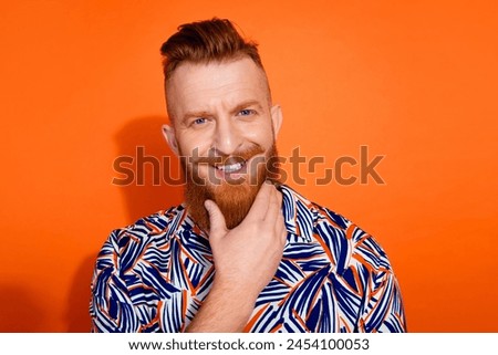 Photo of confident cheerful guy dressed print shirt smiling arm chin empty space isolated orange color background Royalty-Free Stock Photo #2454100053