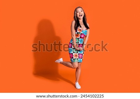 Full length photo of impressed ecstatic cute woman dressed flower print clothes astonished staring isolated on orange color background
